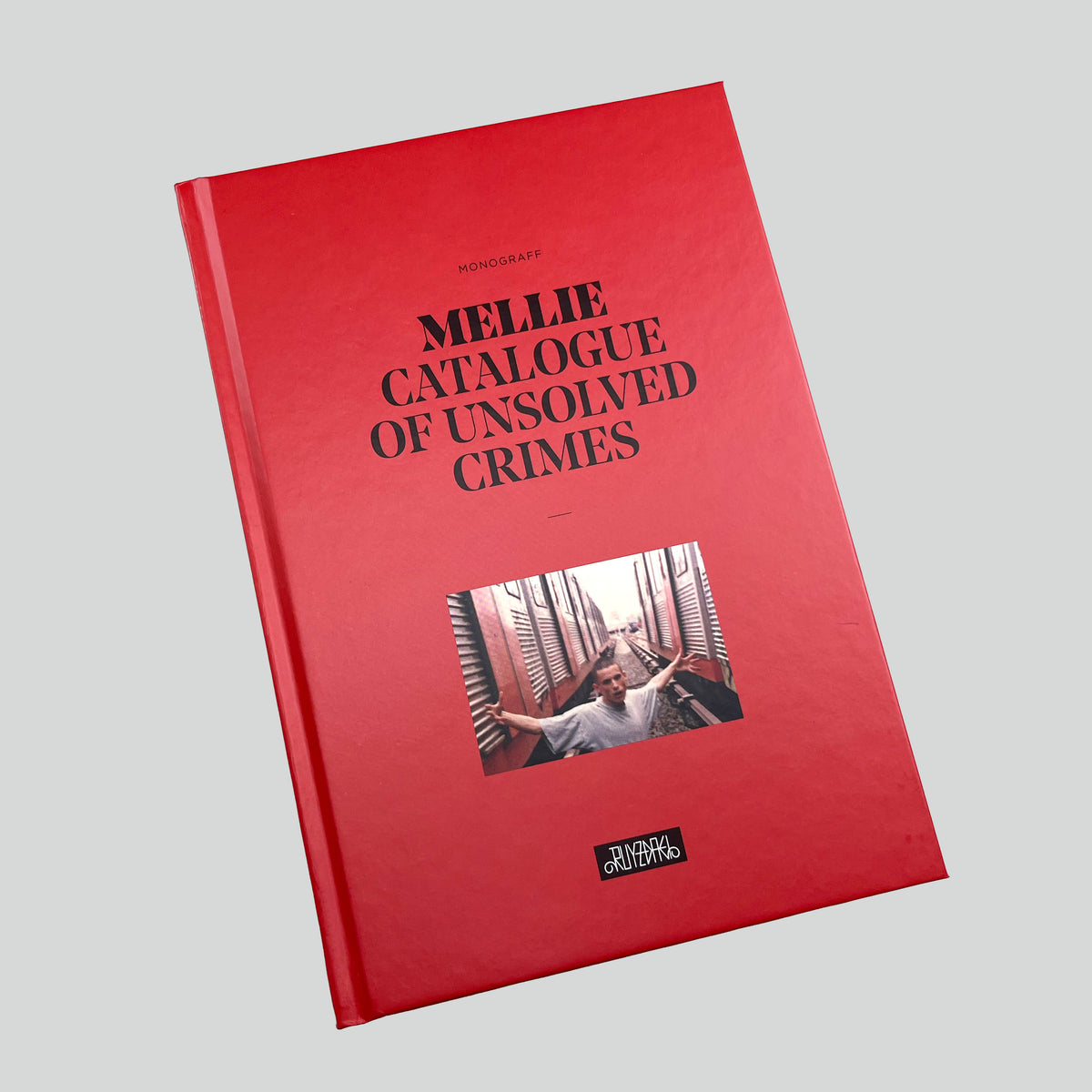 Catalogue of Unsolved Crimes, red hardcover with a photograph on the cover, seen at an angle