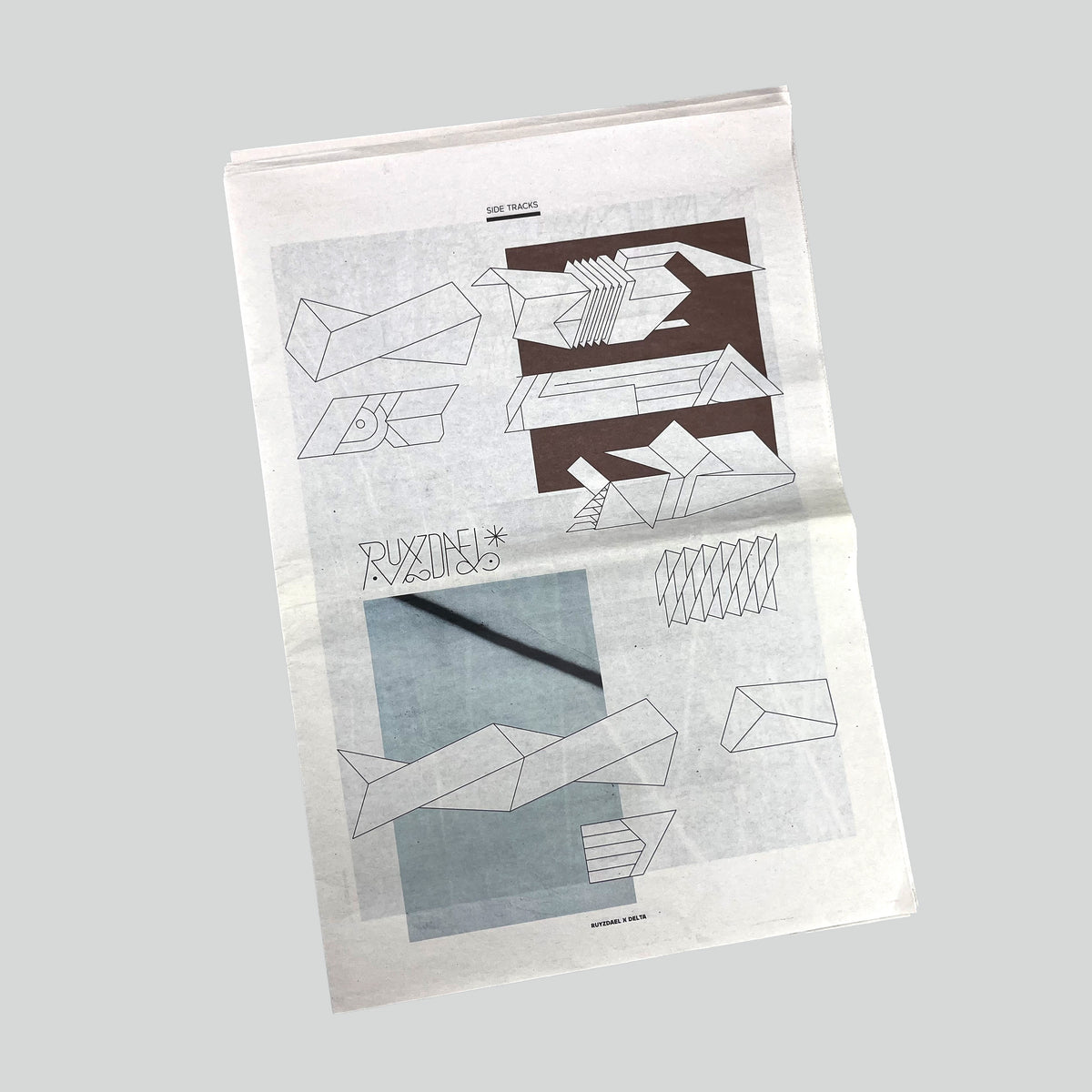 Side Tracks, newsprint cover with line drawings of letters and a photograph, seen at an angle