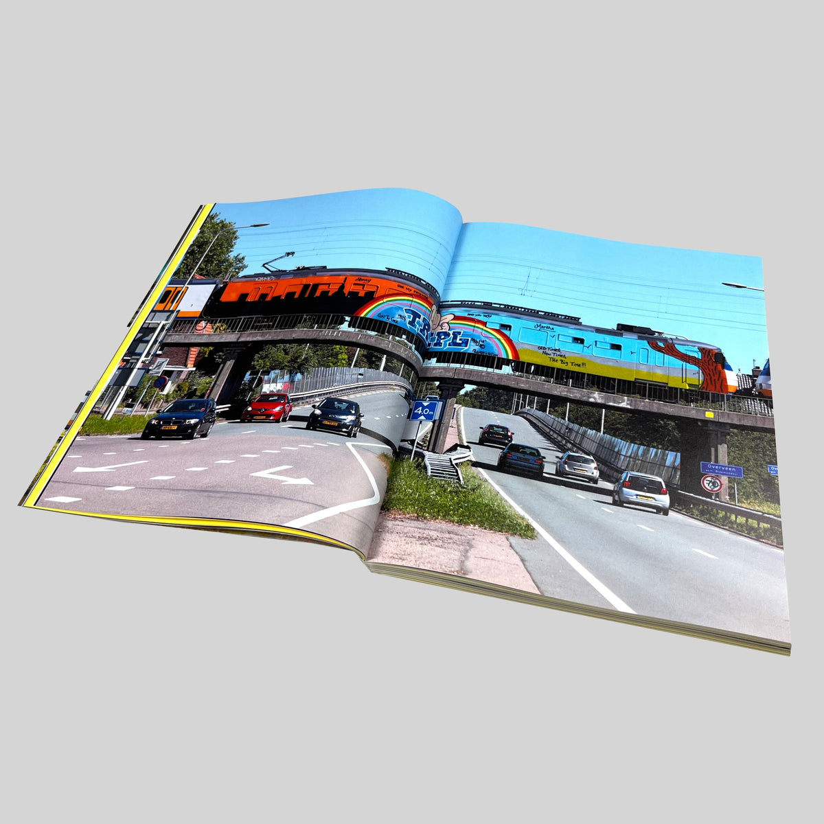 Repainting Subway Art, open spread with a painted train on a bridge above a road