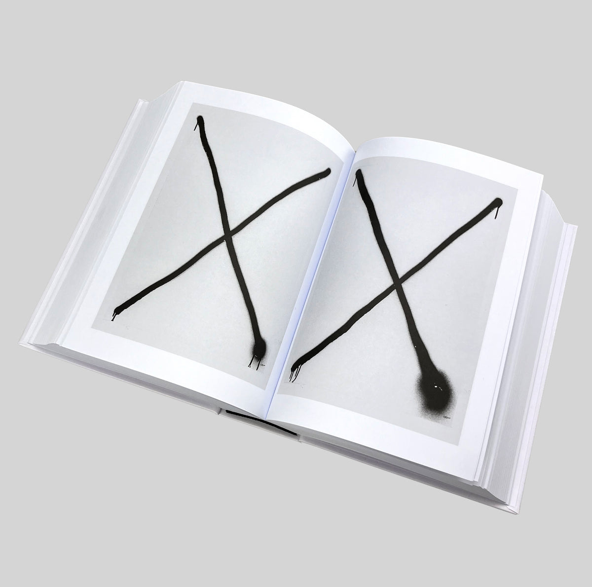 MONOMANIA, open spread with two spray-painted crosses